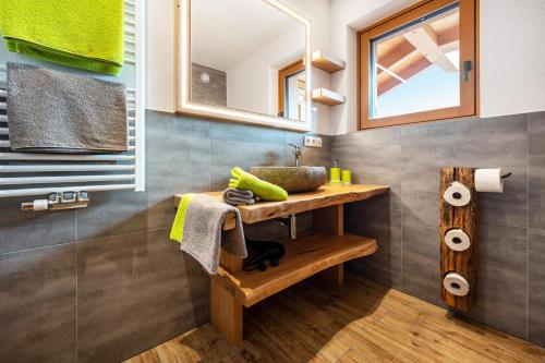 ein Badezimmer mit einem Waschbecken und einem Holztisch in der Unterkunft Forchnerhof Apt 3 in Terenten