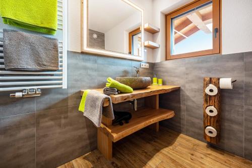 a bathroom with a sink and a wooden table at Forchnerhof Apt 3 in Terento