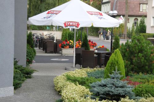 an umbrella in the middle of a garden with flowers at Villa Anna Lisa in Świnoujście