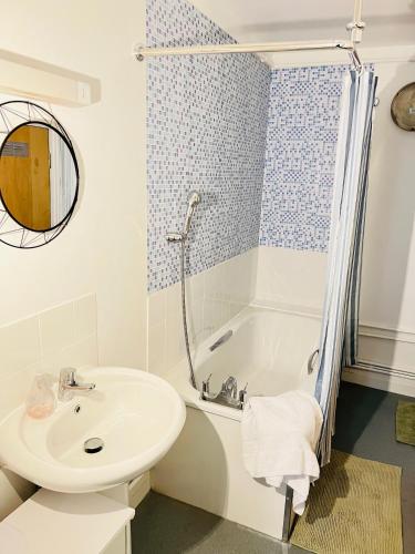 Centrally located modern flat في لندن: حمام أبيض مع حوض وحوض استحمام