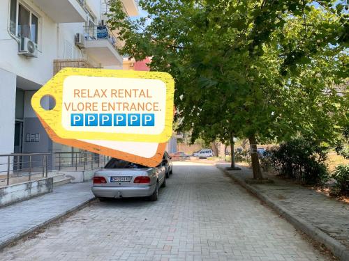 een bord dat leest relaxen huurarbeider entranceropherophe op een straat bij Relax Rental in Vlorë