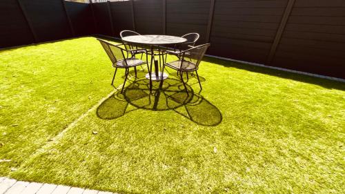 a table and two chairs on a patch of grass at Cozy Charming Bungalow BRAND NEW in Preston