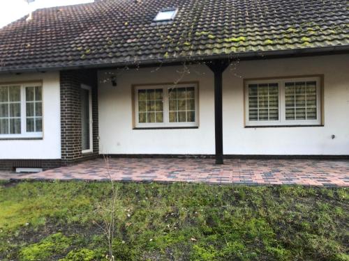 a house with a brick patio and a roof at Ferienhaus Howe in Bergen