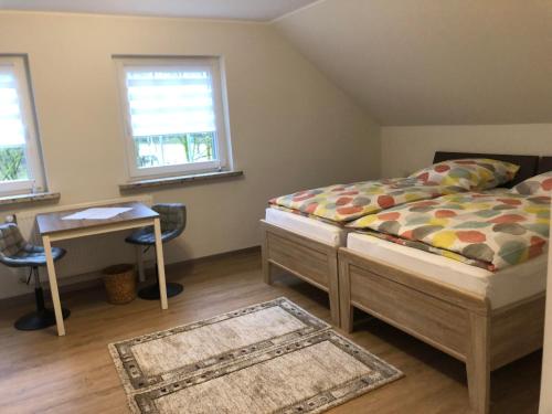 sypialnia z łóżkiem i biurkiem oraz 2 oknami w obiekcie Ferienhaus Howe w mieście Bergen