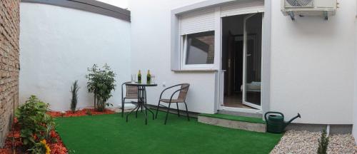 a patio with green grass and a table and chair at Apartments Sava in Zagreb