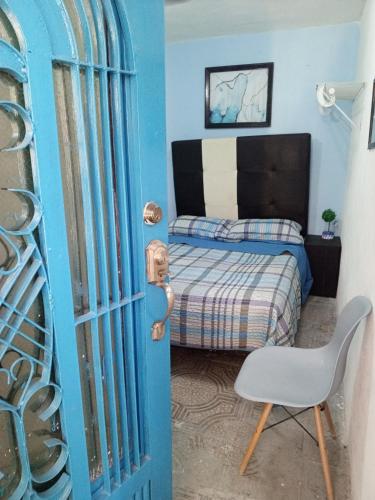 sypialnia z niebieskimi drzwiami z łóżkiem i krzesłem w obiekcie Recámara comodísima y pequeña w mieście Monterrey