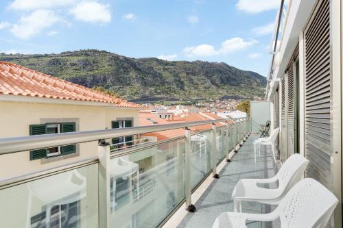 balcón con sillas y vistas a las montañas en Sunny Beach Machico Apartment by HR Madeira, en Machico