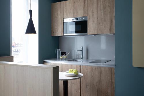 a kitchen with a sink and a microwave above a counter at Bob W Tower Hill Studios in London