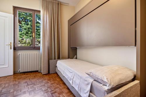 a small bedroom with a bed and a window at La Magrè in Gargnano