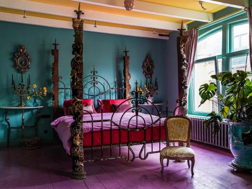 a bedroom with a canopy bed and a chair at Private and chique Salon de Franz - with large terrace in Amsterdam