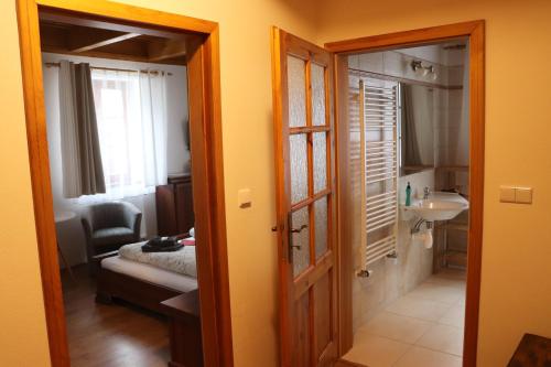 Zimmer mit einem Bad mit einem Waschbecken und einer Tür in der Unterkunft Zevlův mlýn in Nové Hrady