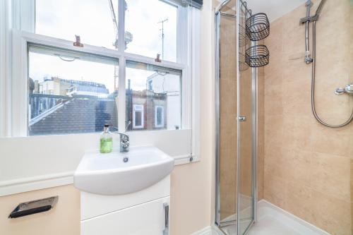 a bathroom with a sink and a window and a shower at Hub townhouse in London