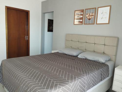 a bedroom with a large bed with two pillows at Sobrado com 3 quartos piscina 100m mar em matinhos in Matinhos