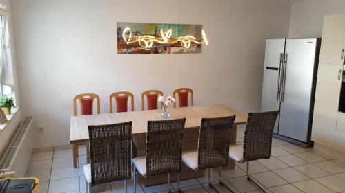 y cocina con mesa, sillas y nevera. en BIG Apartment - 150qm in Bad Liebenwerda en Bad Liebenwerda