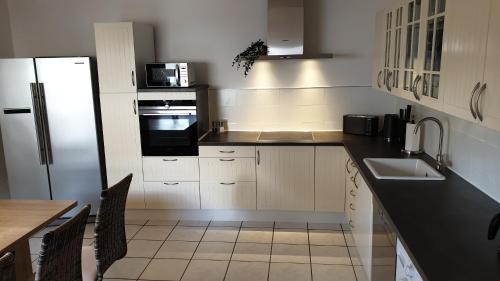 a kitchen with a refrigerator and a sink and a table at BIG Apartment - 150qm in Bad Liebenwerda in Bad Liebenwerda
