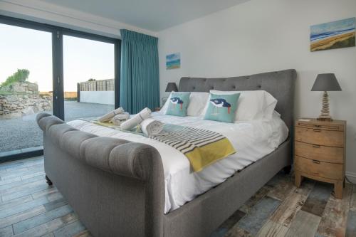 ein großes Bett in einem Schlafzimmer mit großem Fenster in der Unterkunft Cedar Lodge in Carbis Bay