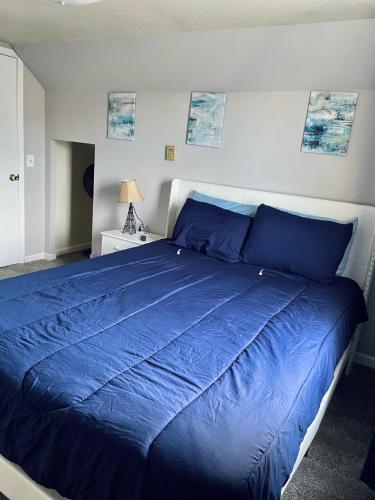 a bedroom with a blue bed with a blue comforter at Vibrant 2 Bed Located Downtown Close to Soaring Eagle CMU in Mount Pleasant