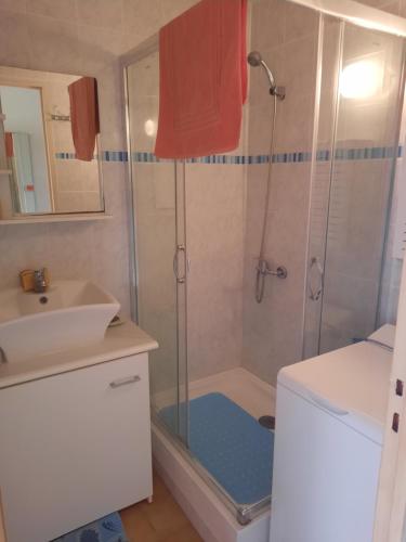 une salle de bain avec douche et lavabo dans l'établissement FACE ECOLE DE VOILE LA PLAGE A 50 metres, à Bernières-sur-Mer