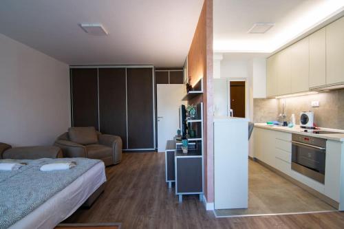 a small room with a bed and a kitchen at Sava centar-Stark Arena lux apartman Ema in Novi Beograd