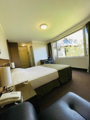 a hotel room with two beds and a window at Hotel Casagrande in Arequipa