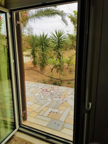 a glass window with a view of a garden outside at Gianna Seaside in Koutsounari