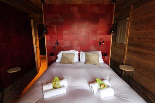 a large bed in a room with a red wall at Chalet Niyama in Font-Romeu-Odeillo-Via