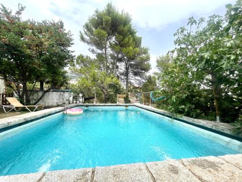 una piscina en un patio con árboles en Casa Fidelina IV Miraflores de la Sierra, en Miraflores de la Sierra