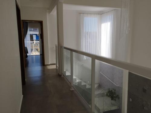 a stairway with a glass railing and a window at Sobrado com 3 quartos piscina 100m mar em matinhos in Matinhos