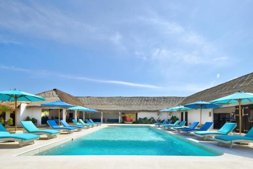 a swimming pool with blue chairs and umbrellas at Mocean Beach Resort in Lemonga