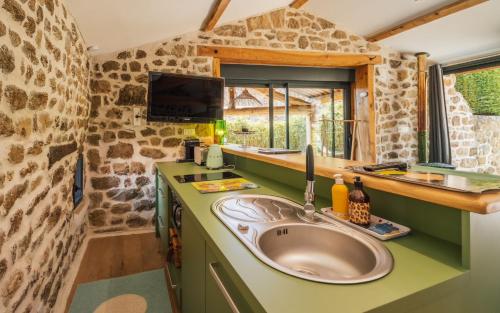 uma cozinha com um lavatório numa pequena casa em La Chomotte em Saint-Alban-dʼAy