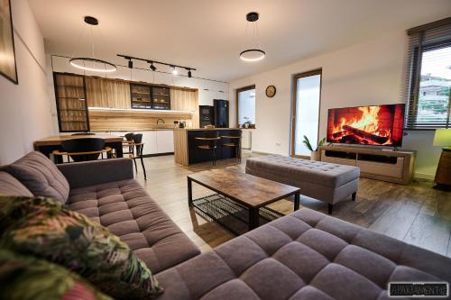 ein Wohnzimmer mit einem Sofa und einem Tisch sowie eine Küche in der Unterkunft Apartament 12 in Chojnice