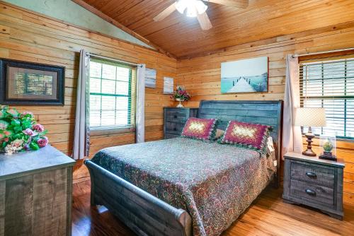 1 dormitorio con 1 cama en una cabaña de madera en Kilgore Gem Pet-Friendly Cabin with Duck Pond!, en Kilgore