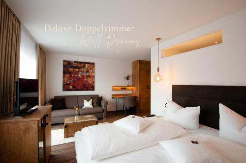a bedroom with two beds and a living room at Hotel Schwaiger in Glonn