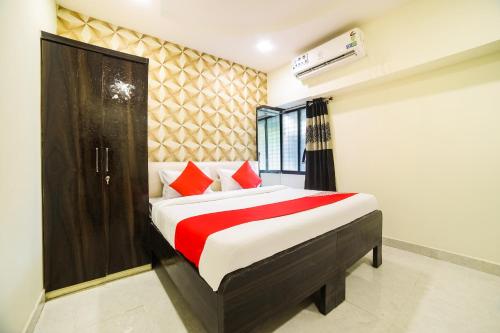 a bedroom with a large bed with red pillows at OYO Hotel Sonali in Nagpur