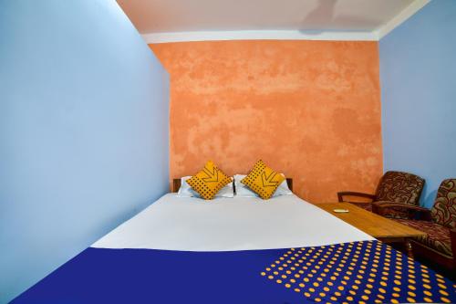 1 Schlafzimmer mit einem Bett und 2 Stühlen in der Unterkunft SPOT ON Shashi Prabha Palace in Deoghar