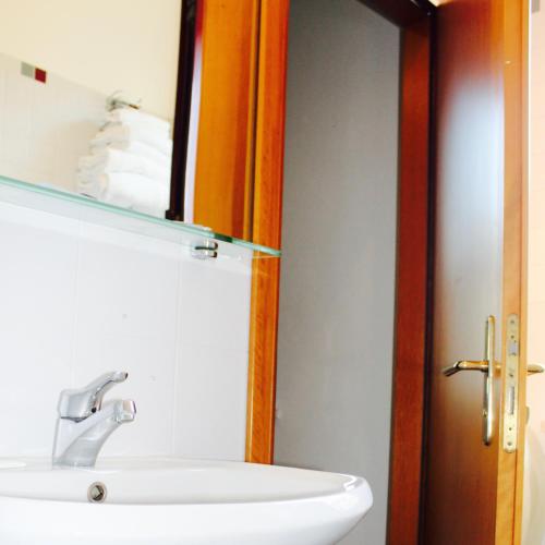 a bathroom with a sink and a mirror at Arcangelo Roof Hotel in Rimini