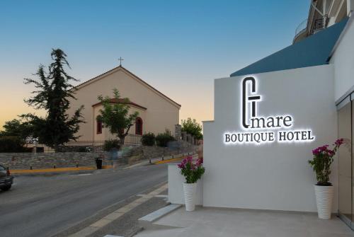 a sign for a boutique hotel on a street at G Mare Boutique Hotel in Neos Marmaras