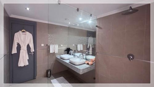 une salle de bain avec un lavabo et un miroir dans l'établissement Hotel Al Massira, à Laâyoune