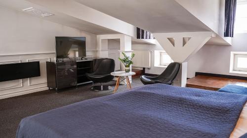 a bedroom with a blue bed and a desk at Hotel Grodzka 20 in Lublin