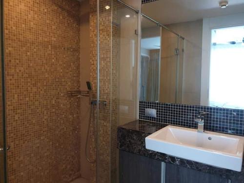 a bathroom with a sink and a glass shower at Centara Avenue 2 Bedrooms Pool View in Pattaya