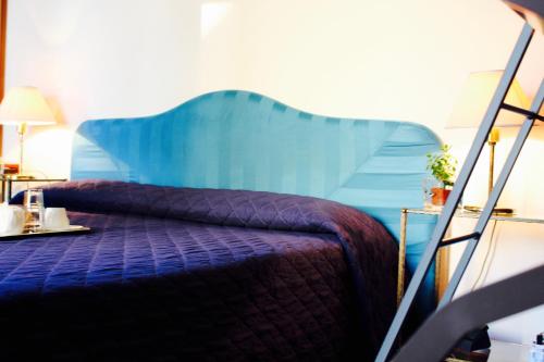 a bedroom with a bed with a blue head board at Arcangelo Roof Hotel in Rimini