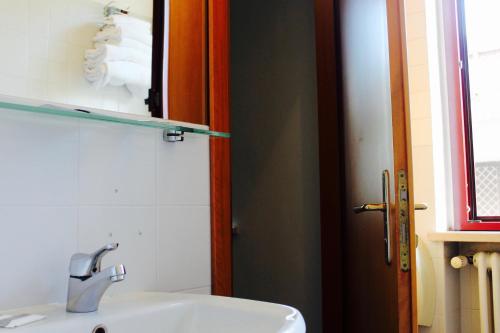 a bathroom with a sink and a toilet and a mirror at Arcangelo Roof Hotel in Rimini