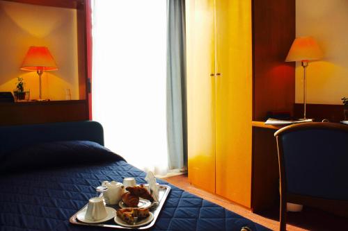 a hotel room with a tray of food on a bed at Arcangelo Roof Hotel in Rimini
