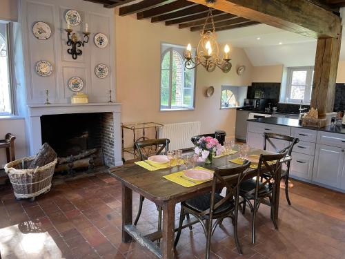 une salle à manger avec une table et une cheminée dans l'établissement maison de charme à 1h 30 de Paris, à Saint-Éman