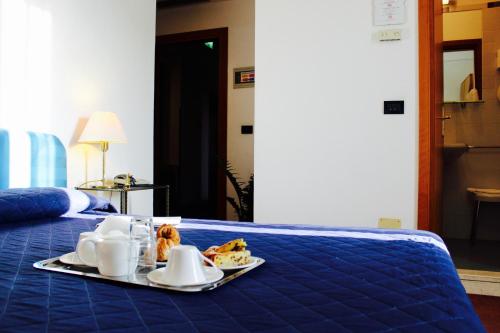 a blue bed with a tray of food on it at Arcangelo Roof Hotel in Rimini
