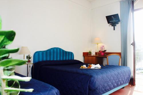 a bedroom with a blue bed with a tray of food on it at Arcangelo Roof Hotel in Rimini
