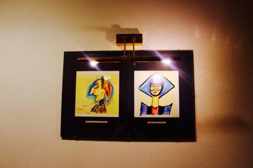 two framed pictures on a wall with lights at Arcangelo Roof Hotel in Rimini