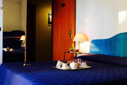 a hotel room with a tray of food on a bed at Arcangelo Roof Hotel in Rimini