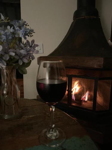 a glass of wine sitting next to a fireplace at Chalés Paraty Real in Paraty