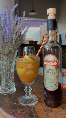 a bottle of alcohol sitting next to a drink at Chalés Paraty Real in Paraty